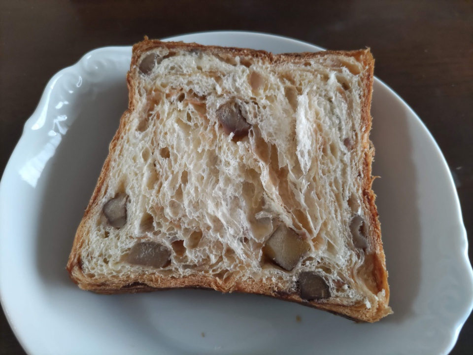 高級スイーツデニッシュ栗1斤をカットし、白いお皿にのせた断面写真。層状のデニッシュ生地の中に栗がごろごろと入っている様子が分かる。