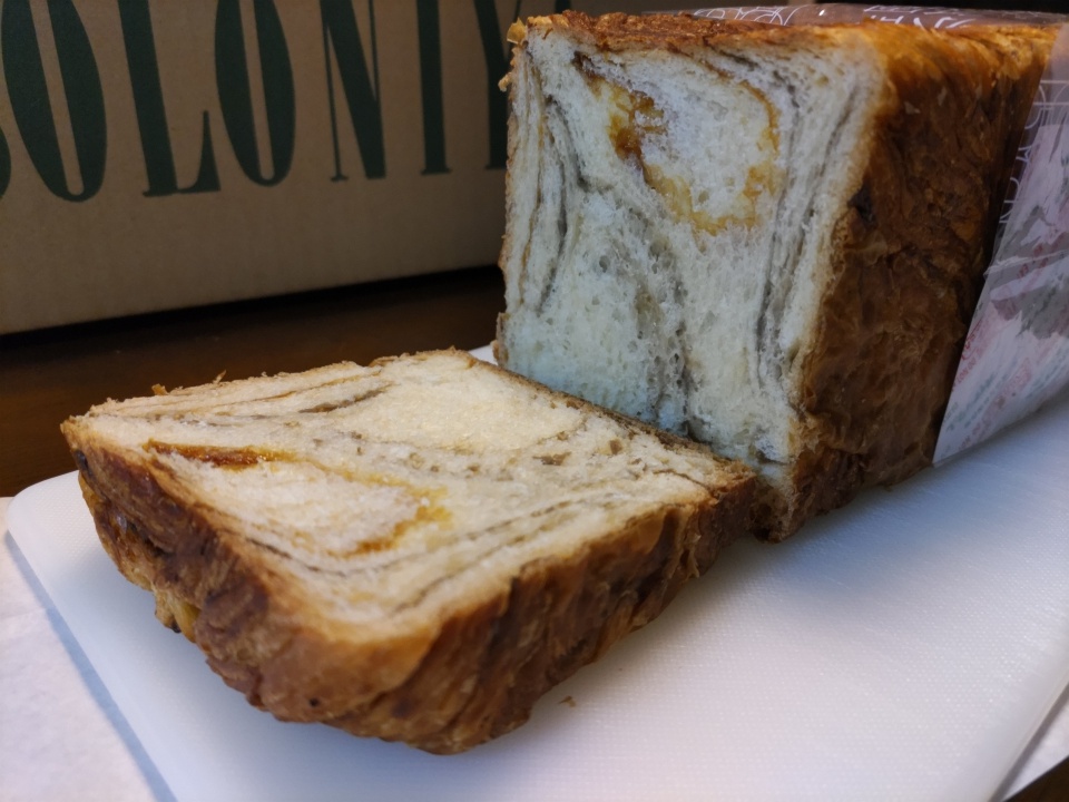 京都祇園ボロニヤの「はんなりデニッシュ キャラメルコーヒー」1斤をカットした断面の写真。層状に重なったデニッシュ生地の中に、キャラメルコーヒーのマーブル模様が広がり、しっとりとした質感が伝わる。