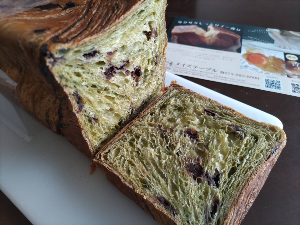 メイズテーブルのスイーツデニッシュ「Wチョコ抹茶」1斤をカットした写真。抹茶色の生地の中にチョコレートが練り込まれた断面が見え、白いまな板の上に切り分けたデニッシュが置かれている。