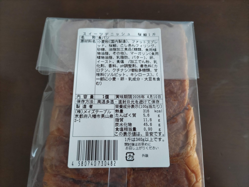 桜餡デニッシュのパッケージ裏面ラベルの写真。原材料、栄養成分、賞味期限（2026年4月10日）などの商品情報が記載されている。