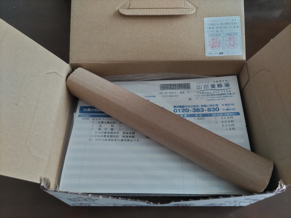 開封直後のダンボール箱の中に、山田養蜂場の納品書と緩衝材の紙筒が入っている様子を写した写真。箱のフタは開かれており、商品を取り出す前の状態が確認できる。