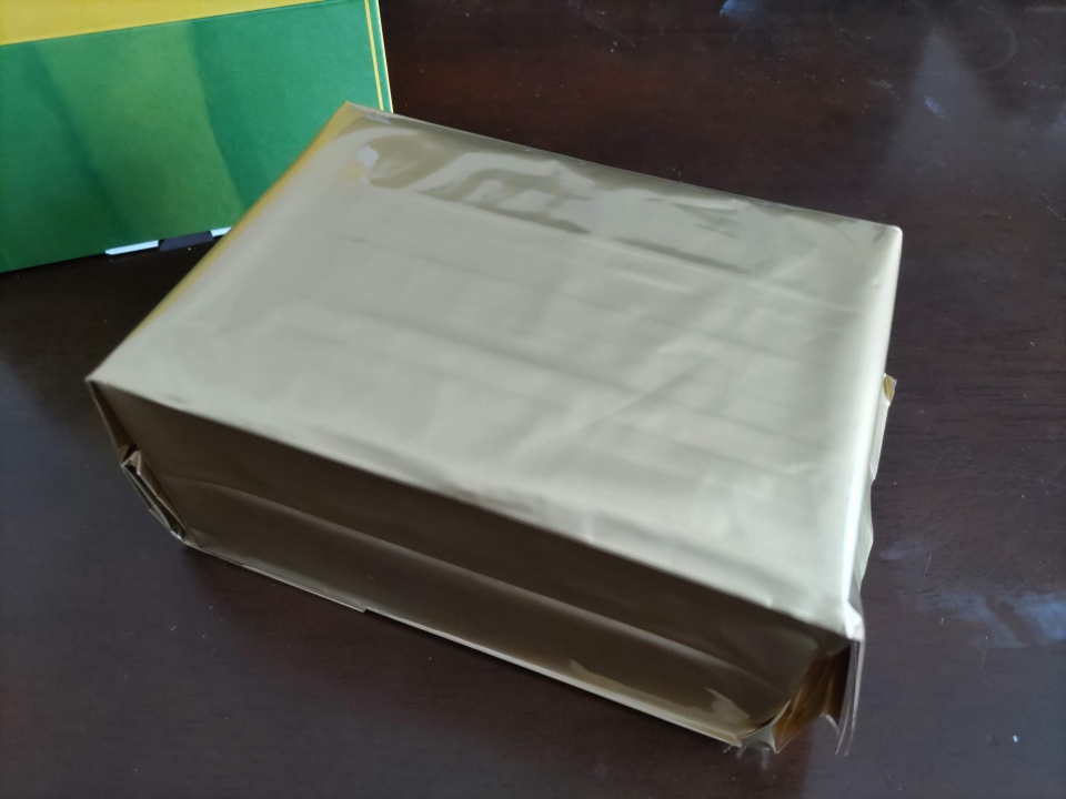 森半の極上手作り宇治抹茶カステラを化粧箱から取り出した様子。カステラ本体は金色の袋で丁寧に包装されている。