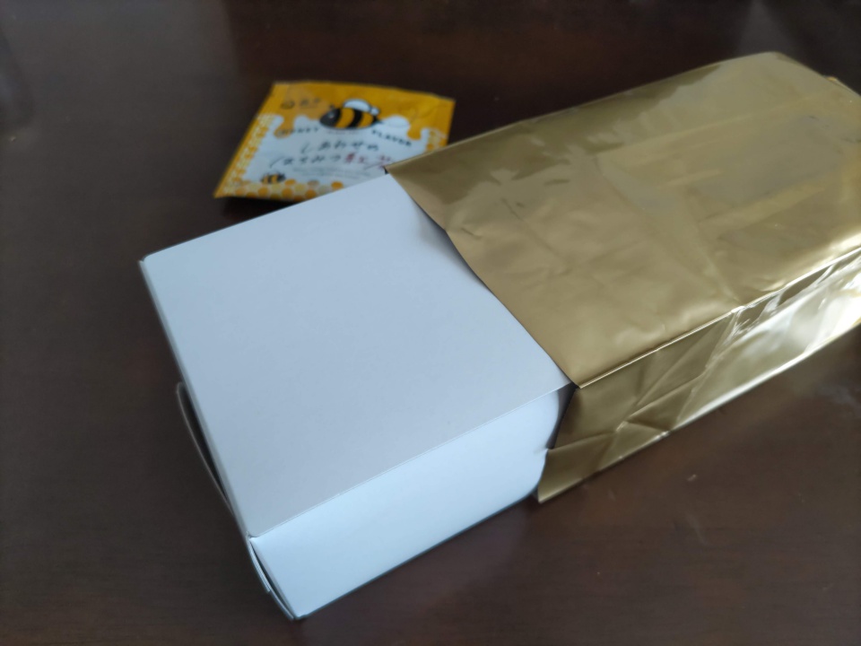 金色の袋を開封した森半の極上手作り宇治抹茶カステラ。中から白い箱に包まれた状態で取り出された様子。