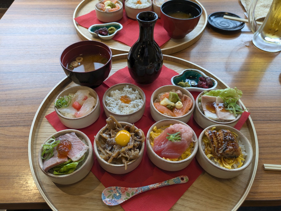 海鮮居酒屋 三ノ宮高架下市場のおちょこ丼ランチ8種。刺身やしらす、サーモン、まぐろ、うなぎなどの小丼と味噌汁が並ぶ